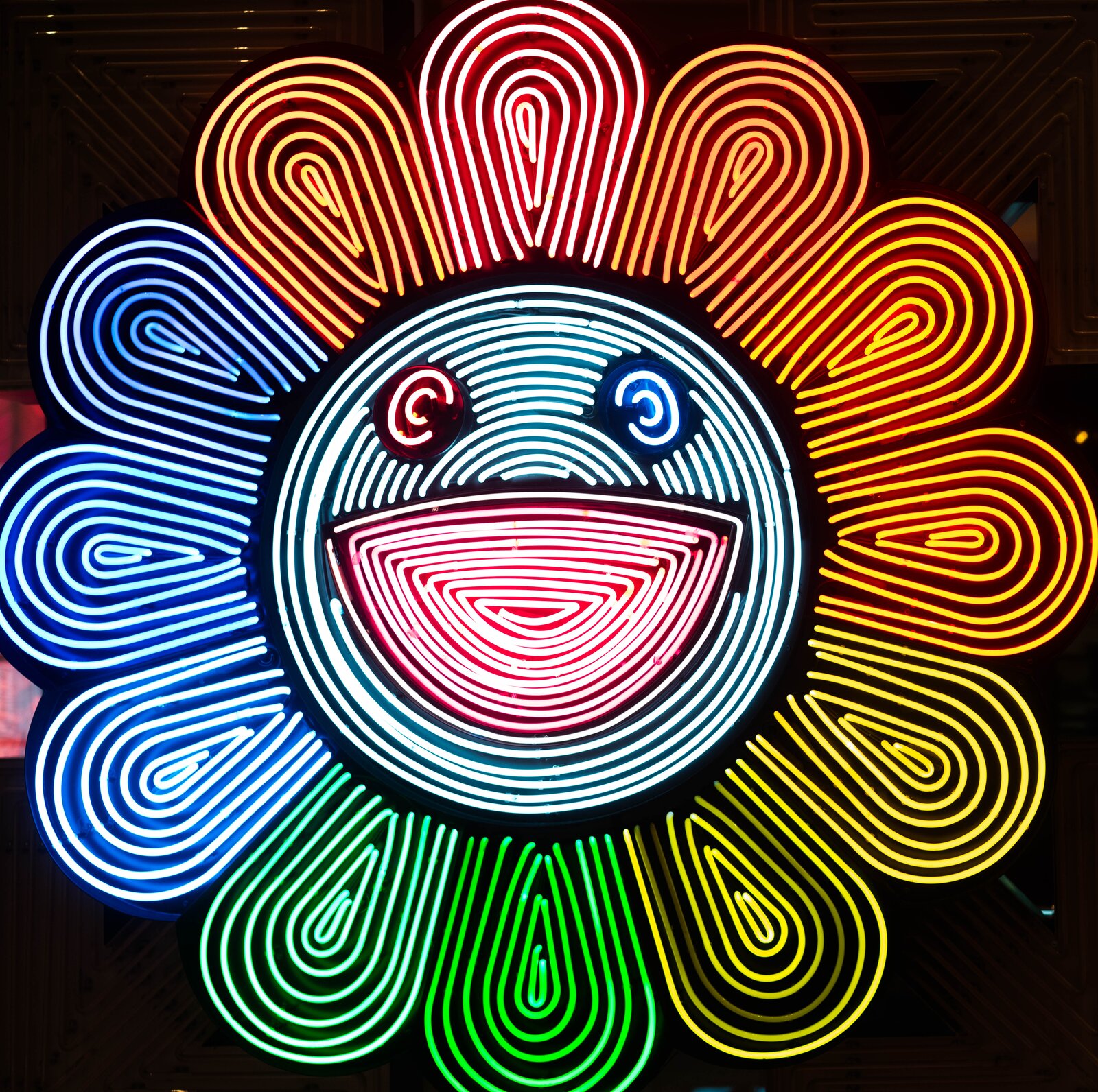 A Murakami-style neon flower on a wall